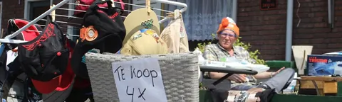 Uitgestalde spulletjes met een handgeschreven bordje 'te koop'
                              op een kleedje tijdens de rommelroute.